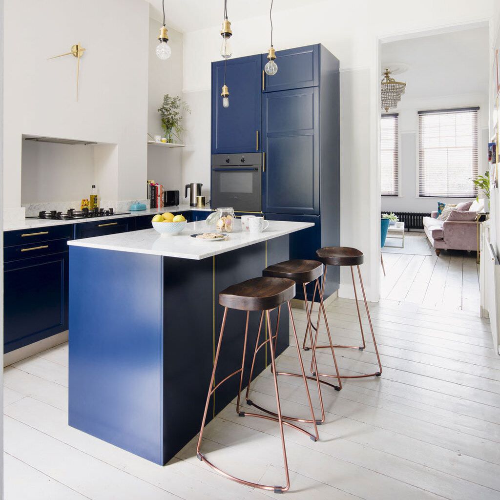 Bàn đảo bếp kết hợp bàn ăn màu xanh lạ mắt cùng bộ ghế cao làm điểm nhấn thu hút cho cả gian bếp nhỏ